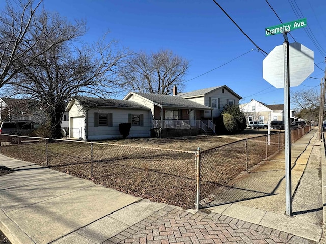 view of side of property featuring a garage and a fenced front yard