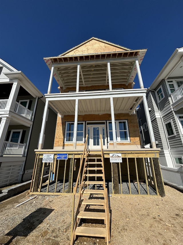 view of property with stairs, fence, and covered porch