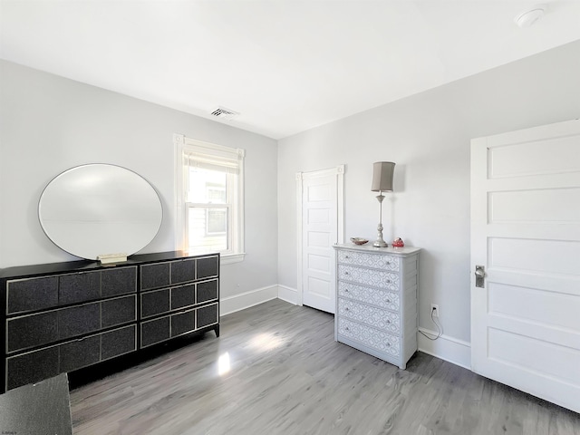 bedroom featuring visible vents, baseboards, and wood finished floors