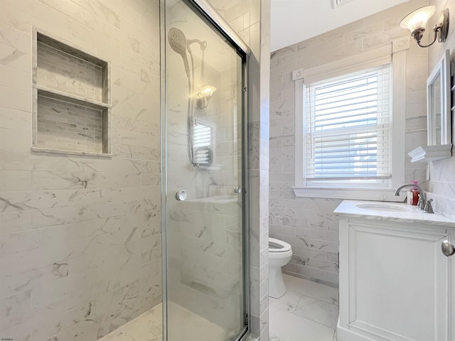 bathroom with marble finish floor, a stall shower, tile walls, and vanity