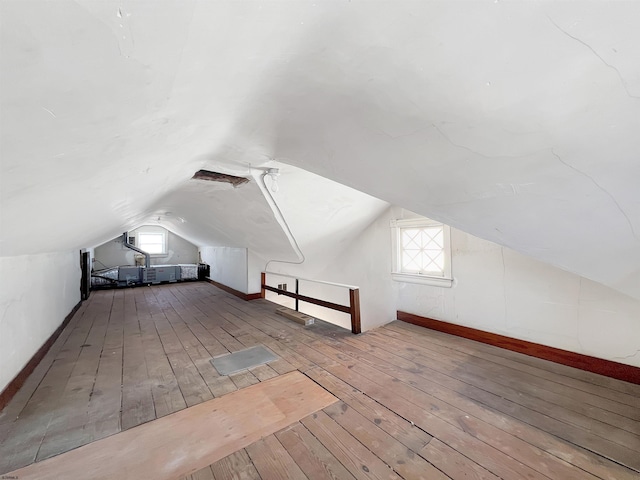 bonus room with hardwood / wood-style floors and vaulted ceiling