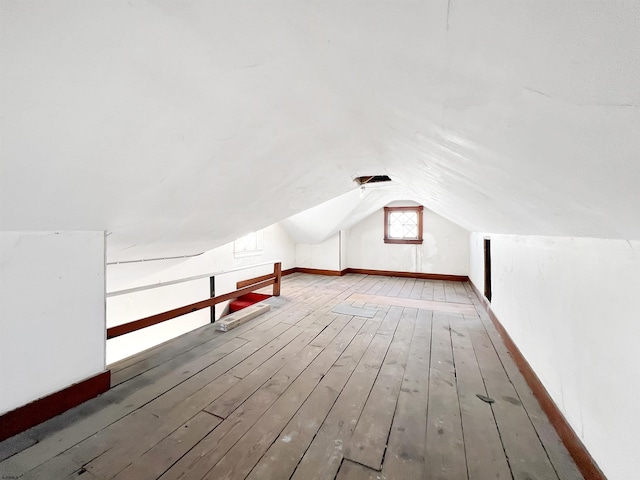 bonus room with hardwood / wood-style flooring, baseboards, and lofted ceiling