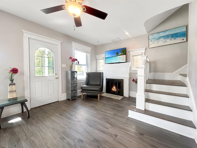 foyer featuring stairway, a fireplace with flush hearth, and wood finished floors