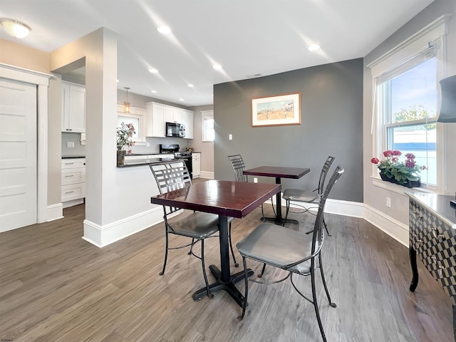 dining room with dark wood finished floors, recessed lighting, and baseboards