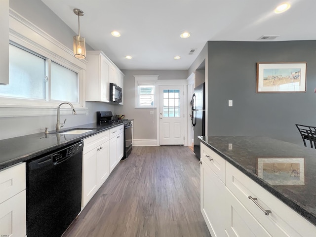 kitchen featuring a sink, black appliances, dark wood finished floors, and white cabinets