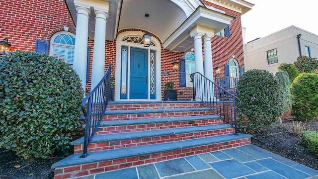 view of exterior entry featuring brick siding