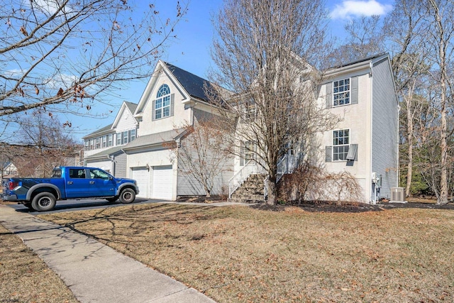 view of front of home featuring stucco siding, a front lawn, central AC, and an attached garage