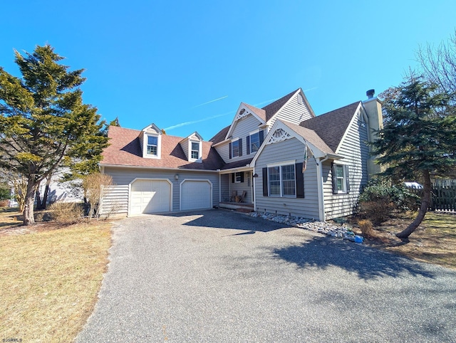 view of front of property with an attached garage, a shingled roof, and driveway