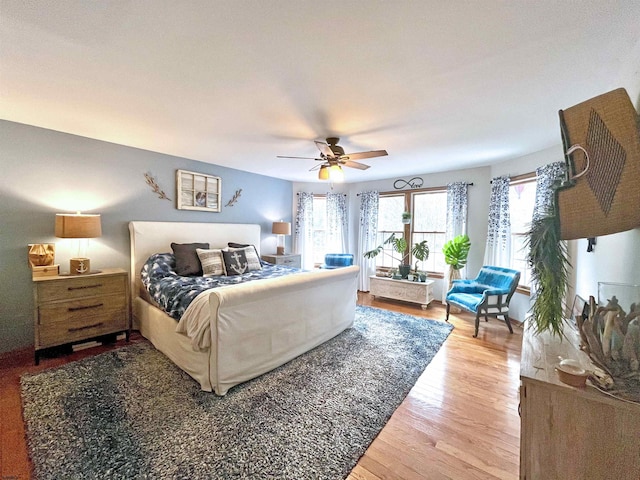 bedroom featuring light wood-type flooring, a ceiling fan, and access to outside