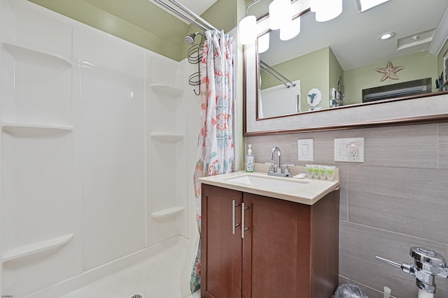 full bath featuring decorative backsplash, a shower stall, and vanity