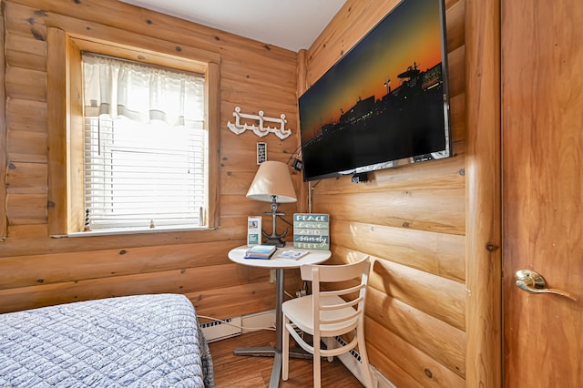 bedroom with wood finished floors, multiple windows, and wood walls