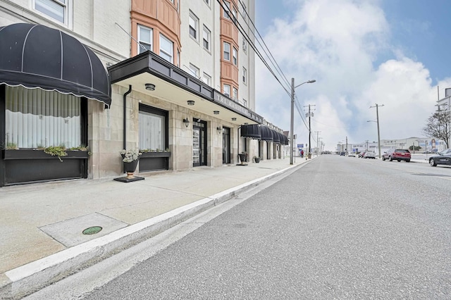 view of street featuring curbs, sidewalks, and street lighting