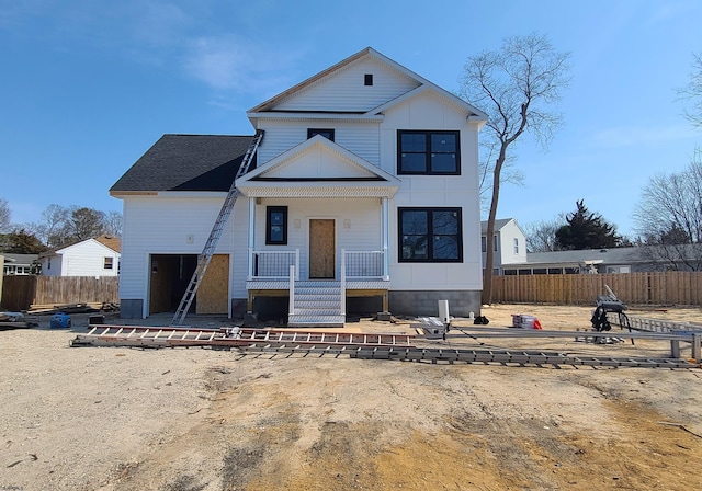 view of front facade with a patio area, covered porch, roof with shingles, and fence