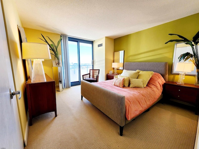 bedroom featuring expansive windows, visible vents, access to exterior, a textured ceiling, and light colored carpet