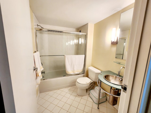 full bath with a sink, enclosed tub / shower combo, toilet, and tile patterned flooring