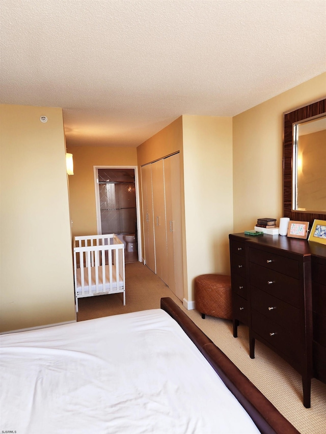 carpeted bedroom with a closet and a textured ceiling