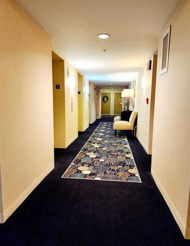 hallway with visible vents, baseboards, and carpet