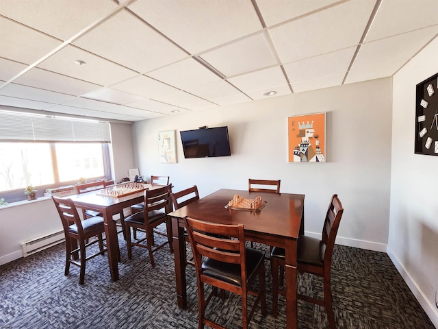 dining space with carpet flooring, a paneled ceiling, baseboards, and baseboard heating