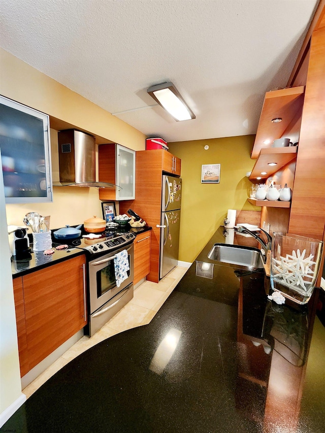 kitchen featuring a sink, dark countertops, a textured ceiling, stainless steel appliances, and wall chimney range hood