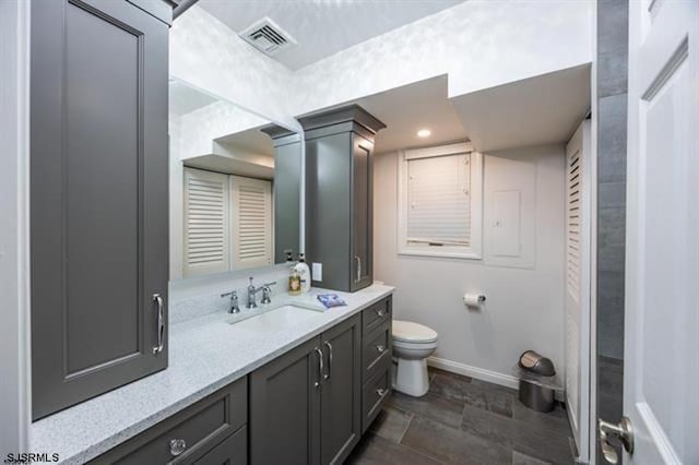 bathroom featuring visible vents, toilet, recessed lighting, baseboards, and vanity