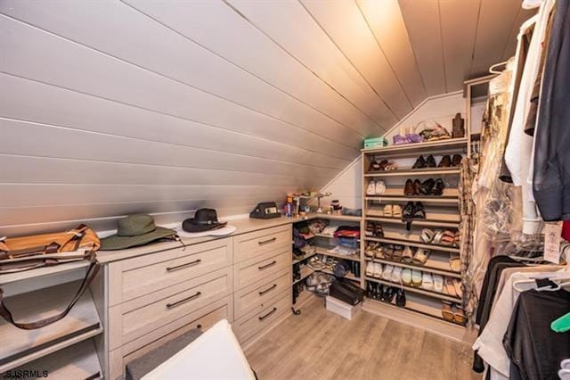 spacious closet with light wood-type flooring and vaulted ceiling