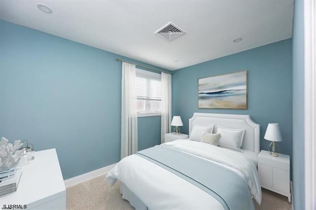 carpeted bedroom featuring baseboards and visible vents