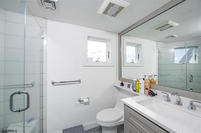 bathroom with vanity, a shower stall, toilet, and visible vents