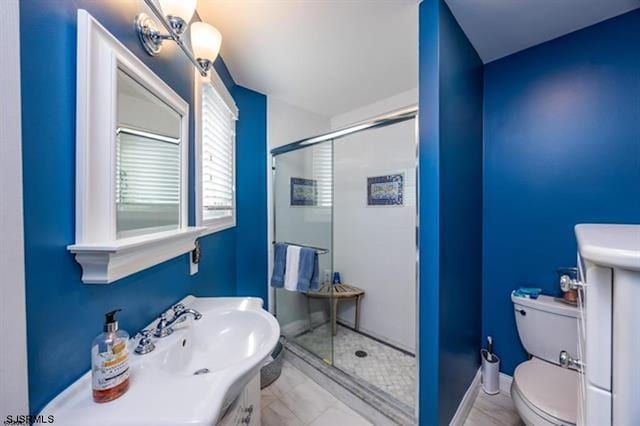 bathroom featuring a shower stall, toilet, vanity, and baseboards