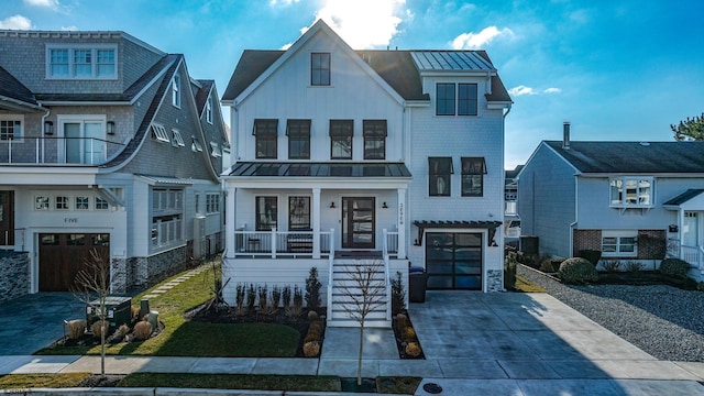 view of front of house featuring covered porch, driveway, metal roof, and a standing seam roof