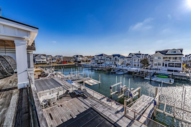 view of dock with boat lift, a residential view, and a water view