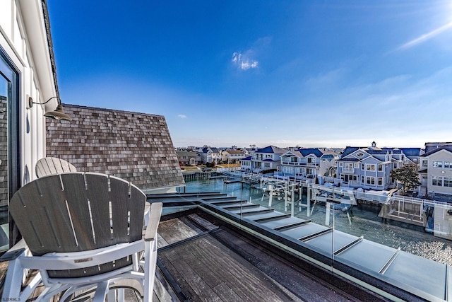 balcony featuring a residential view and a water view