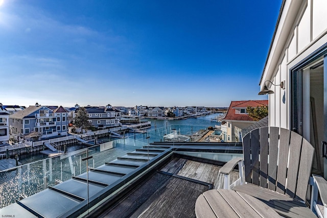 balcony featuring a residential view and a water view