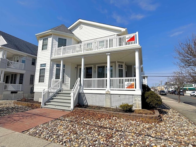 view of front of property featuring a balcony and covered porch