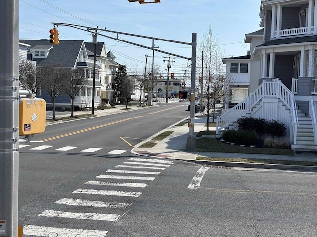 view of road with curbs, traffic lights, and sidewalks