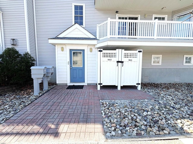 view of exterior entry featuring crawl space and a balcony