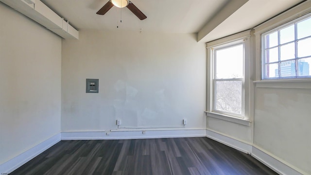 unfurnished room with ceiling fan, baseboards, and dark wood finished floors