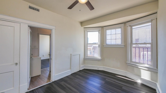 interior space featuring visible vents, baseboards, dark wood finished floors, and a ceiling fan