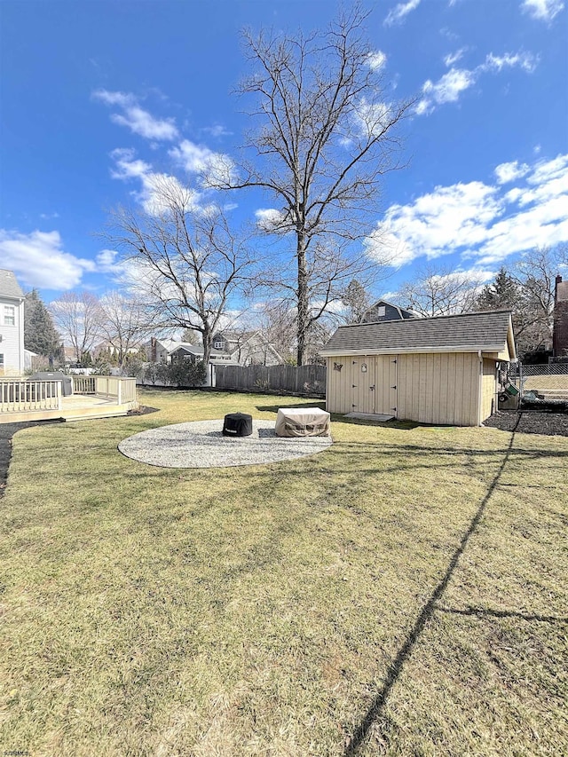 view of yard with an outbuilding, an outdoor fire pit, and fence