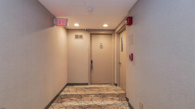 hall with light tile patterned floors, visible vents, recessed lighting, and a textured wall