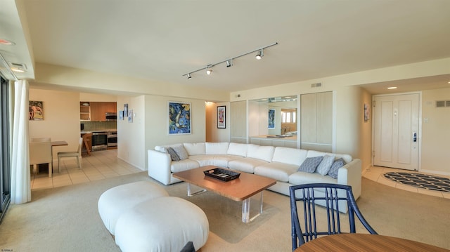 carpeted living room with visible vents, rail lighting, and tile patterned flooring