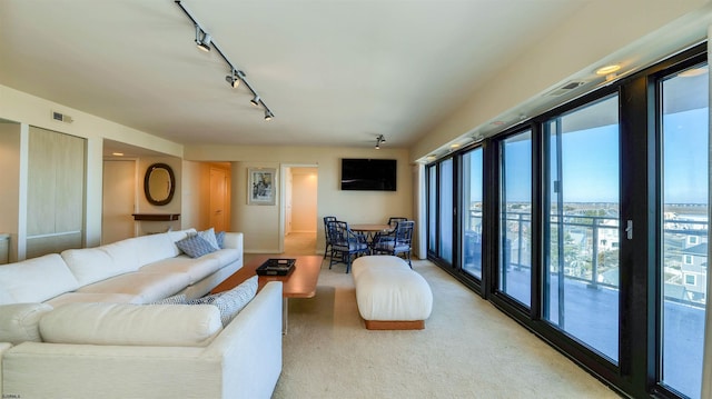 living area featuring visible vents, light carpet, and rail lighting