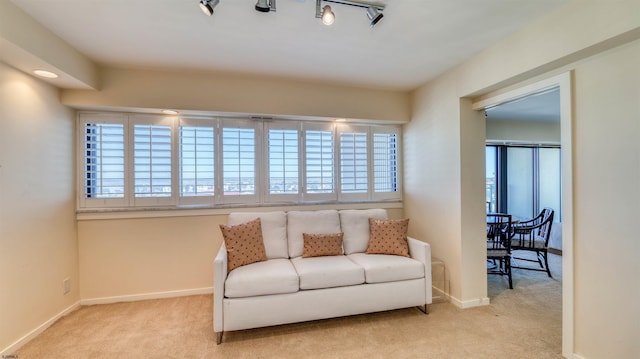 living area with baseboards and carpet