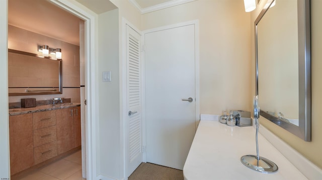 full bath with tile patterned flooring, vanity, a closet, and ornamental molding