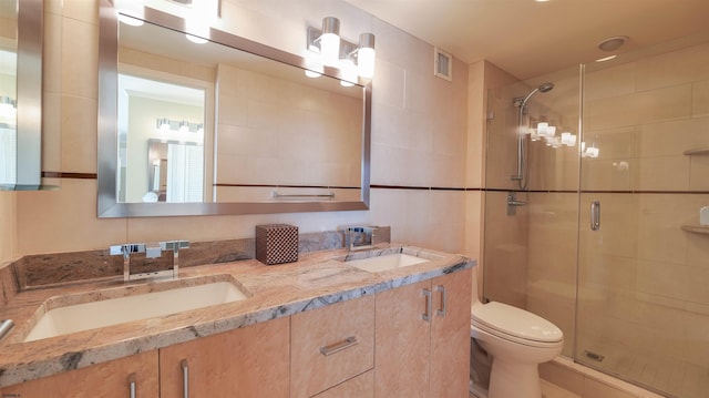 bathroom featuring a sink, toilet, and a stall shower