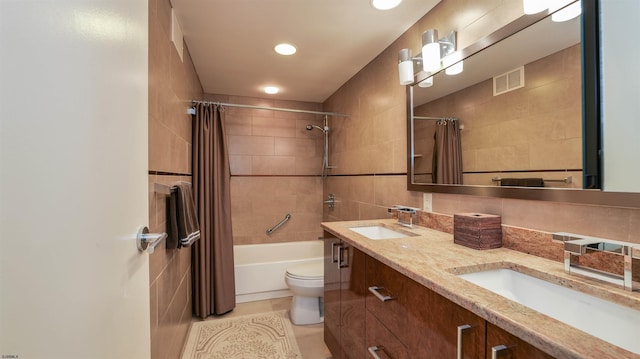 bathroom with a sink, visible vents, shower / bath combo with shower curtain, and toilet