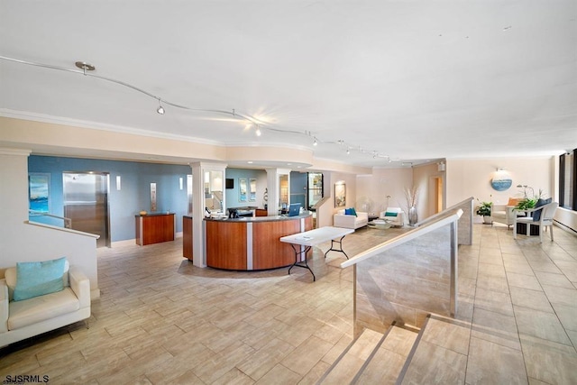 interior space featuring rail lighting, open floor plan, and crown molding