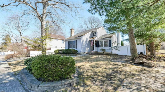 view of front of property featuring entry steps, fence, and a chimney