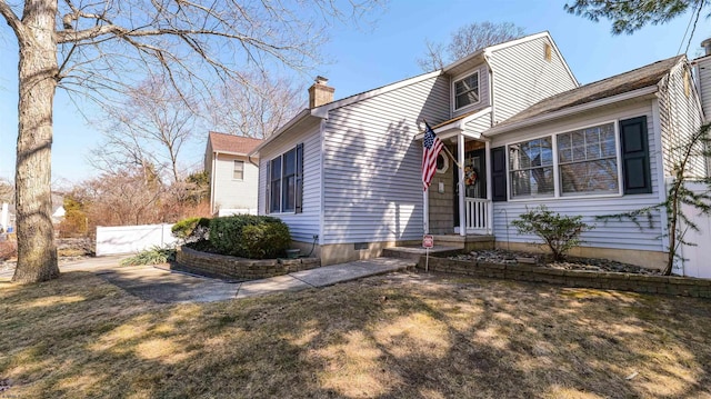 view of front of home with fence and a chimney