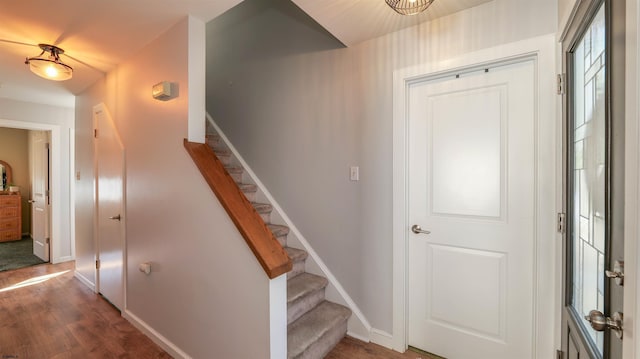 stairway with wood finished floors and baseboards