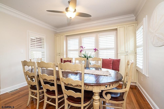 dining room with visible vents, baseboards, wood finished floors, and crown molding